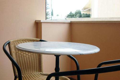 a white table and two chairs and a window at Vittoria Resort Residence-B&B in Galatina