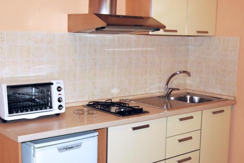 a kitchen with a sink and a microwave at Vittoria Resort Residence-B&B in Galatina