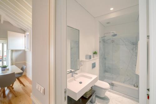 een badkamer met een wastafel, een douche en een toilet bij Villa Baixa - Lisbon Luxury Apartments in Lissabon