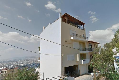 a white building with a balcony on top of it at Private pool & Panorama View on Athens center Hill in Athens