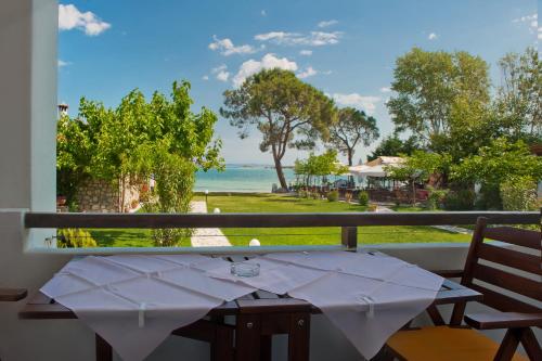 a table on a balcony with a view of the ocean at Kamares House Apartments & Studios in Vourvourou