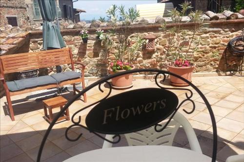 a chair with the word flowers on it next to a bench at Casa Benoi in Rigomagno
