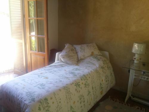 um quarto com uma cama com um edredão branco e uma janela em Villa Marina em Jerez de la Frontera