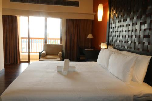 a hotel room with a large bed and a chair at Millennium Suite At Pyramid Tower in Petaling Jaya