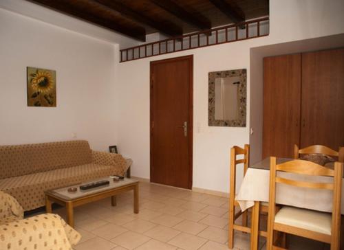 a living room with a couch and a table at Sunny Apartments in Makry Gialos