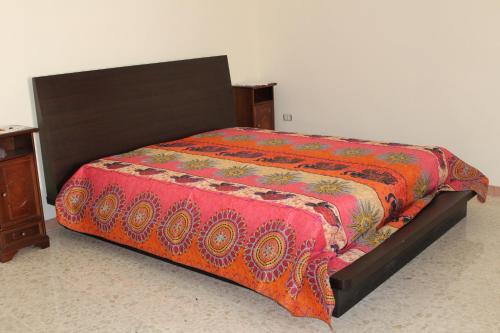un letto con un piumone rosso sopra di esso di AnVi Apartment a Pollena Trocchia