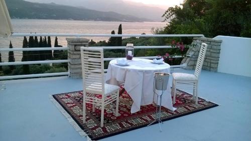 a table and chairs on a balcony with a view of the water at Scorpios Hotel & Suites in Samos