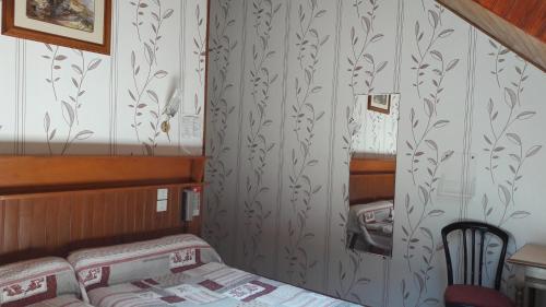 a small bedroom with a bed and a staircase at Hôtel Saint Jean in Vals-les-Bains