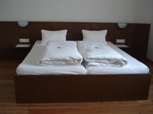 a large bed with white sheets and pillows on it at Gästehaus Obwexer in Matrei in Osttirol