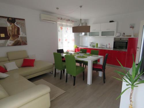 cocina y sala de estar con mesa y sillas en Apartments Villa Urbajs, en Vrsar