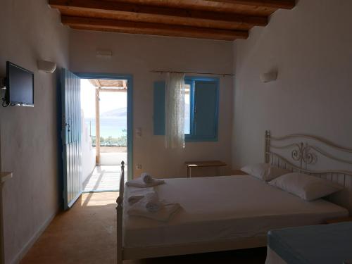 Schlafzimmer mit einem Bett und einer Tür zu einem Balkon in der Unterkunft Apollon Koufonisia Studios in Koufonisia