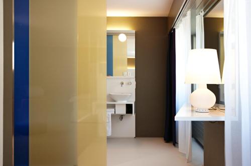 a bathroom with a sink and a lamp on a table at Hotel Restaurant Rössli in Bad Ragaz