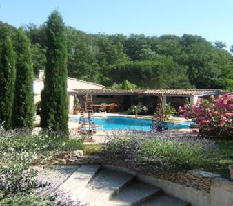 una piscina en un patio con árboles y una casa en Les Chambres d'Hôtes de la Ferrage, en La Tour-dʼAigues