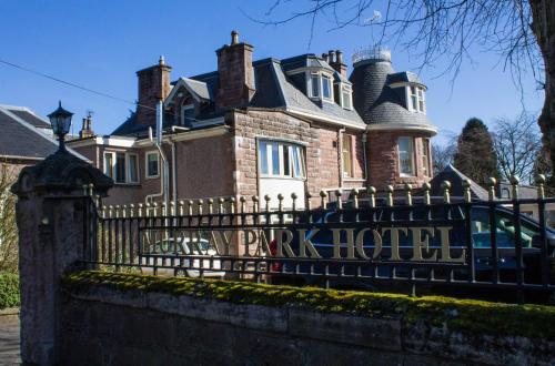 a large house with a black wrought iron fence at The Murray Park Hotel in Crieff