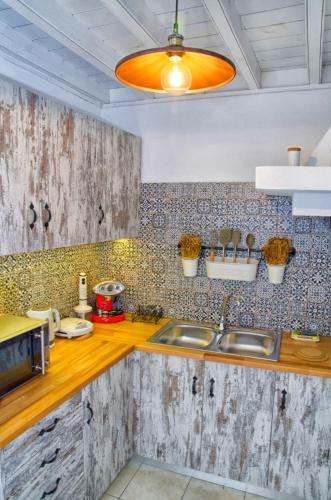a kitchen with a sink and a microwave at Lindos Tholos Villa in Lindos