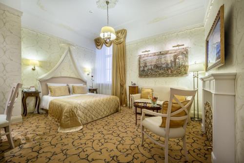 a hotel room with a bed and a table and chairs at Imperial Hotel & Restaurant in Vilnius