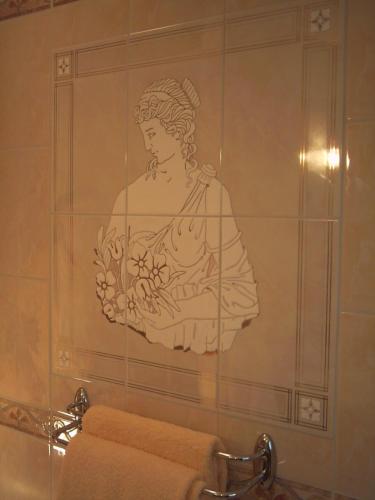 a mural of a woman holding flowers on a bathroom wall at Chambres d'Hôtes La Balaguère in Cauterets