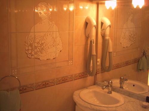 a bathroom with a sink and a phone on the wall at Chambres d'Hôtes La Balaguère in Cauterets
