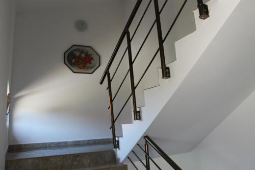 a staircase in a house with a clock on the wall at Guest House Dara in Tsarevo