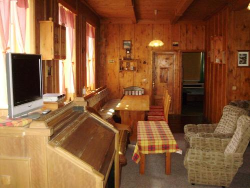 a living room with a television and a table and chairs at Pension nad Truhlárnou in Svoboda nad Úpou