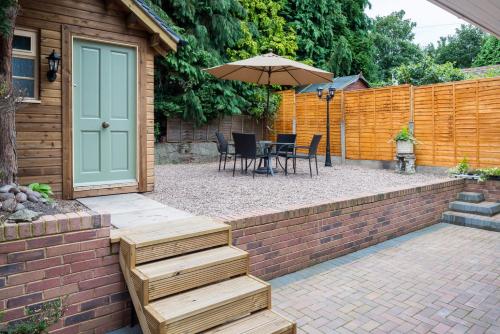 a patio with an umbrella and a table and chairs at Holcombe House in Wolverhampton