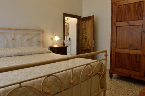 サン・カシャーノ・イン・ヴァル・ディ・ペーザにあるLa Casa di'Grilloのベッドルーム1室(ベッド1台、木製ドレッサー付)