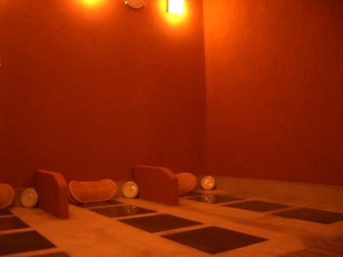 a red room with a sink and two chairs at Meguminoyu in Furano