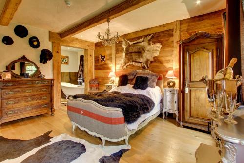 a bedroom with a bed in a room with wooden walls at La Ferme du Lac Vert in Montriond