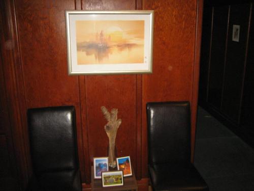a picture hanging on a wall with two chairs at Murrayfield Park Guest House in Edinburgh