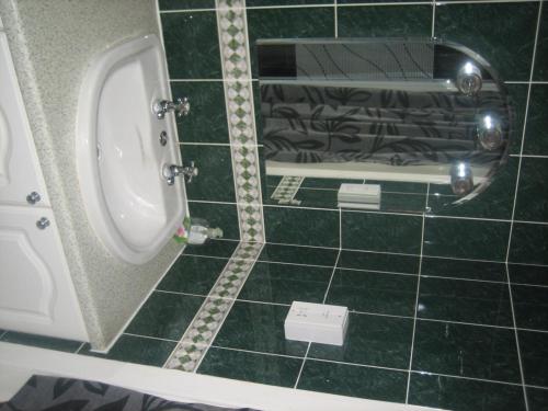 a bathroom with a urinal and a green tiled floor at Murrayfield Park Guest House in Edinburgh