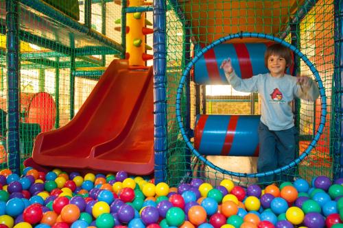 a young boy is playing in a playground with balls at Hotel Aleksandar in Budva