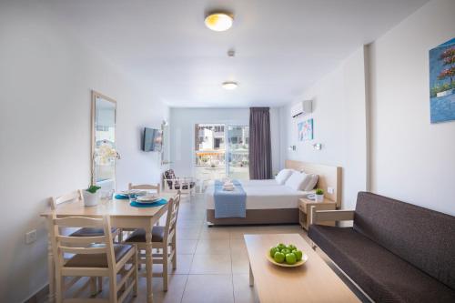 a living room with a bed and a dining room at Christabelle Hotel Apartments in Ayia Napa