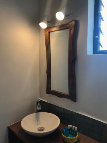 a bathroom with a sink and a mirror on the wall at Pili Pili Boutique Hotel in Kigali