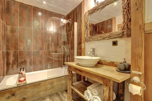 a bathroom with a sink and a tub at La Ferme du Lac Vert in Montriond
