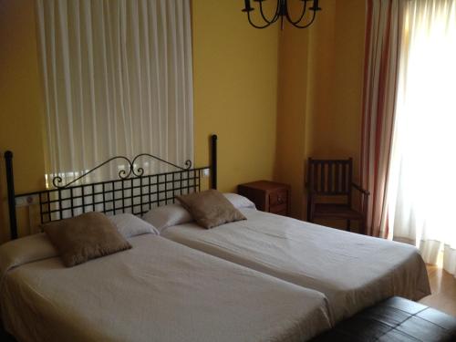 a bedroom with two beds and a window at Hotel Rural Isasi in Gordexola