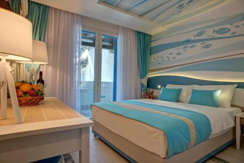 Schlafzimmer mit einem Bett mit blauer und weißer Decke in der Unterkunft Hotel Aleksandar in Budva