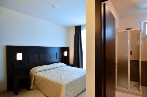 a bedroom with a bed and a glass door at Hotel I Crespi in Grosseto