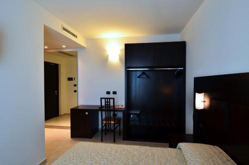 a bedroom with a bed and a desk and a chair at Hotel I Crespi in Grosseto