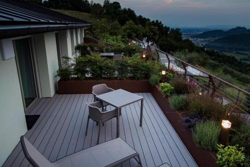 a wooden deck with a table and chair on a balcony at Hotel Ristorante La Rosina in Marostica