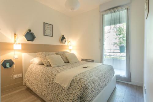 圖盧茲的住宿－Le Jardin Bleu - Dormiratoulouse Basso Cambo，一间卧室设有一张大床和一个窗户。