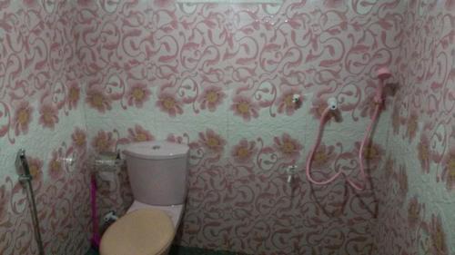 a bathroom with a toilet and a wall covered in graffiti at Peacock Residence & Cabana's in Tangalle