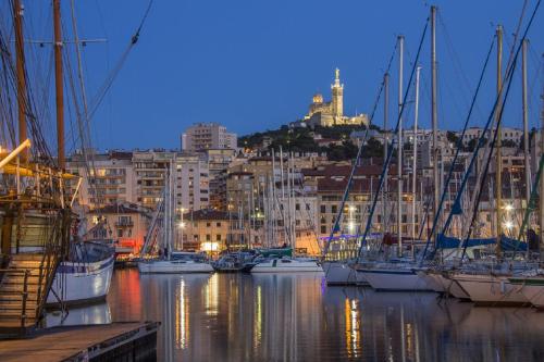 Un grupo de barcos atracados en un puerto deportivo por la noche. en Studio Charles de Gaulle - Vieux Port, en Marsella