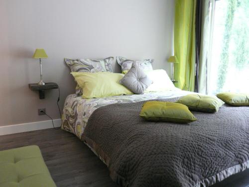 een slaapkamer met een bed met kussens en een raam bij Les 7 Roses d'Aix in Aix-en-Provence