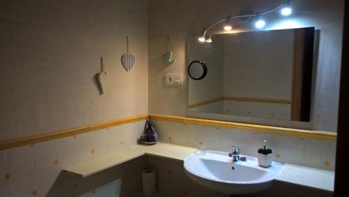 baño con lavabo y espejo grande en Casa Alfredo, en Villamarciel