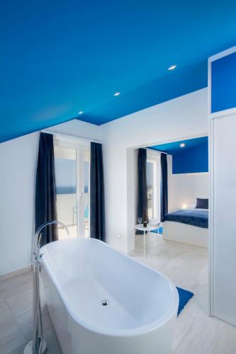 a white bath tub in a room with a bed at Villa Elena in Podstrana