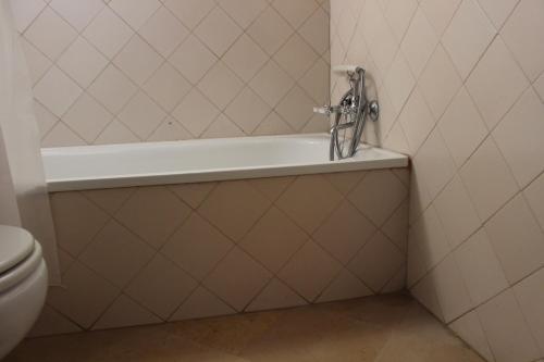 a bath tub in a bathroom with a toilet at Quinta do Valle in Tomar