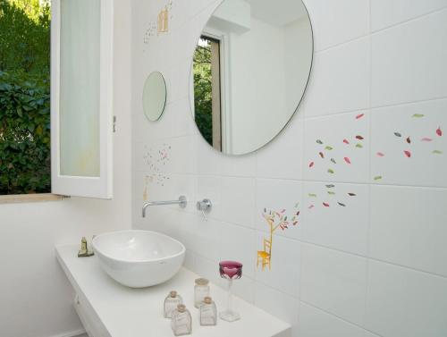 y baño con lavabo blanco y espejo. en Romantic Hotel & Restaurant Villa Cheta Elite en Maratea
