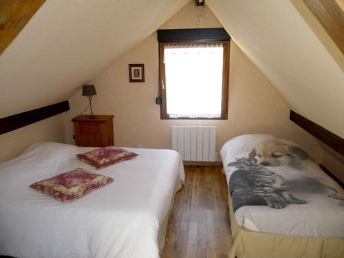 a attic bedroom with two beds with a dog on them at Ferme du Mouton Noir in Lautenbachzell