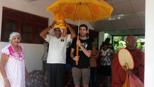 a man holding an umbrella in a group of people at Peacock Residence & Cabana's in Tangalle
