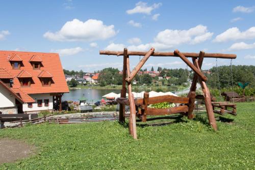 a wooden swing in the grass in a field at Hotel Leyla in Frymburk